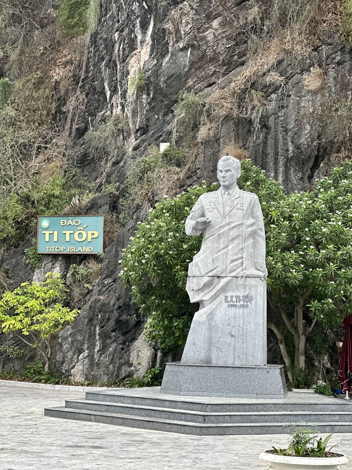 Une statue de Ti Top entourée de verdure sur une île.