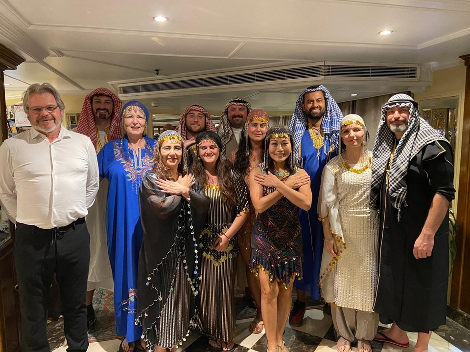 Un groupe de personnes en tenue traditionnelle à bord d'un bateau.