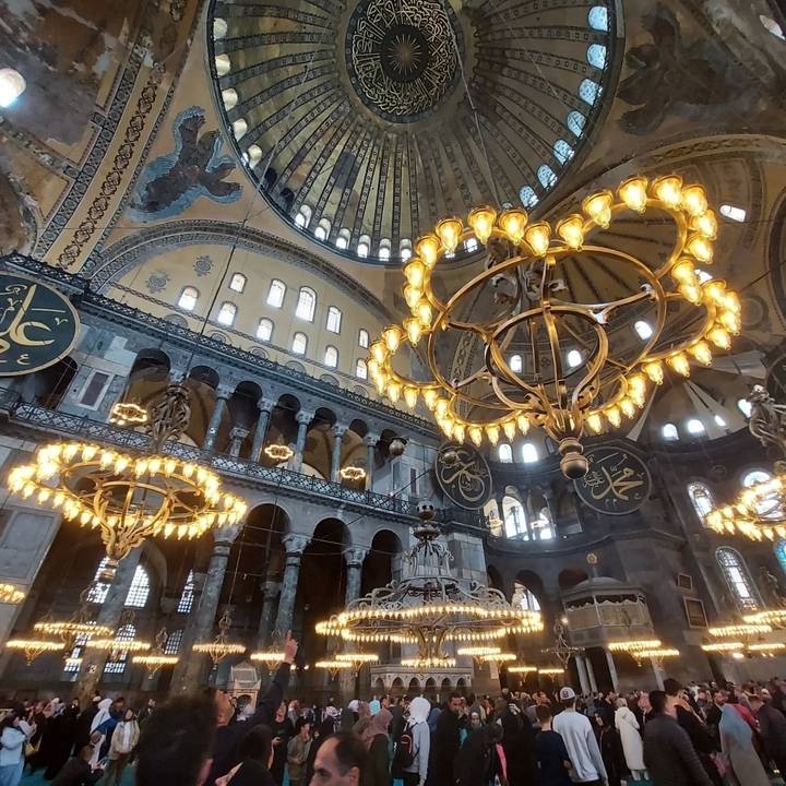Intérieur d'un bâtiment grandiose avec des lustres et des détails architecturaux complexes.