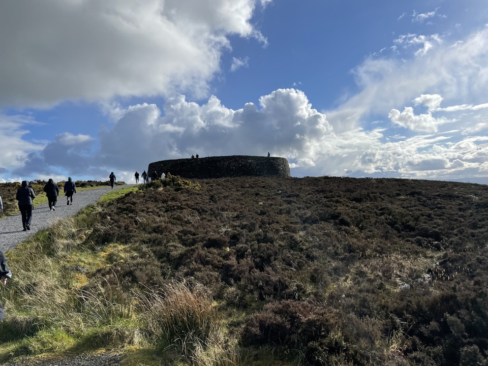 Groupe de personnes marchant vers un fort en pierre.