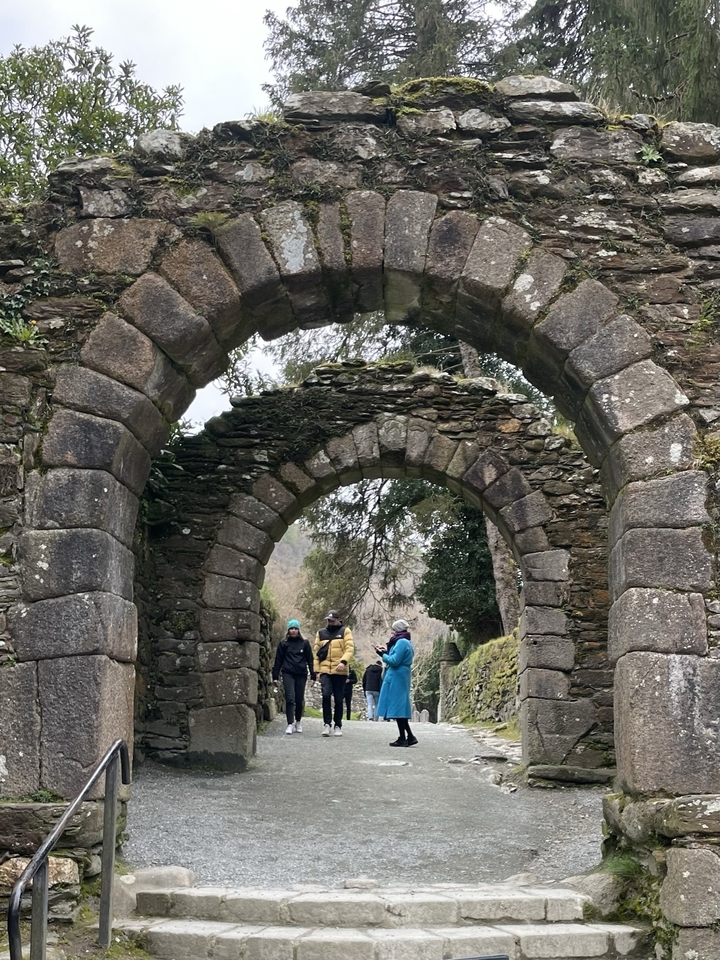 Arche de pierre historique avec des personnes explorant la zone.