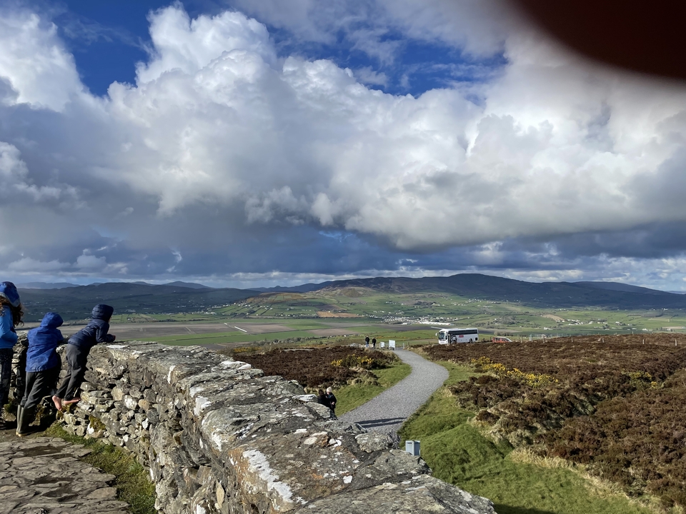 Vue paysagère depuis une colline avec des personnes admirant le paysage.