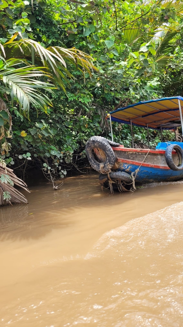 Bateau avec des pneus en guise de pare-battages sur une berge boueuse.