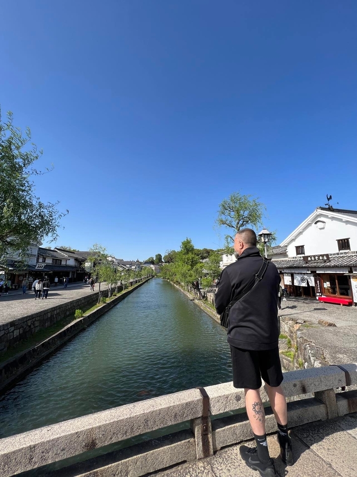 Personne debout près d'un canal dans un quartier historique.