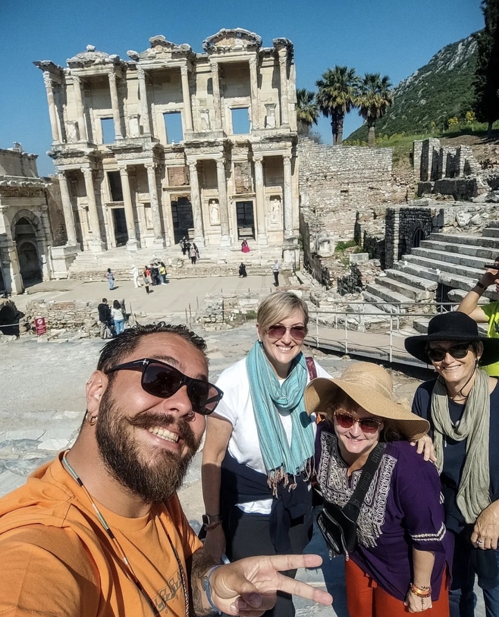 Selfie de groupe devant des ruines antiques avec des colonnes.