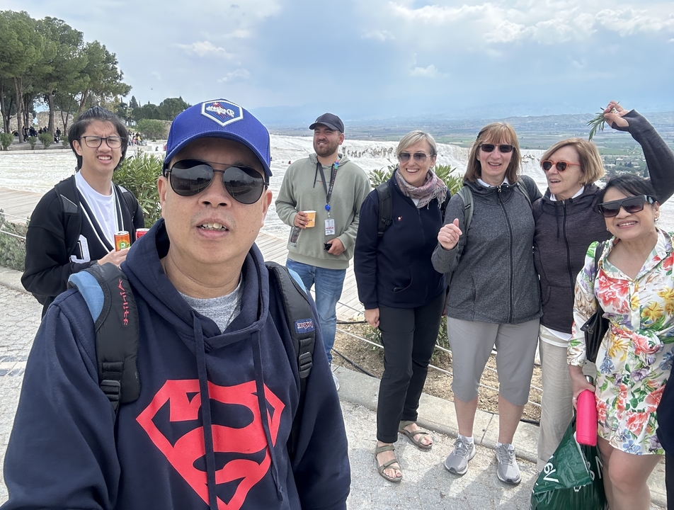 Groupe de touristes avec en arrière-plan des terrasses de travertin blanc.