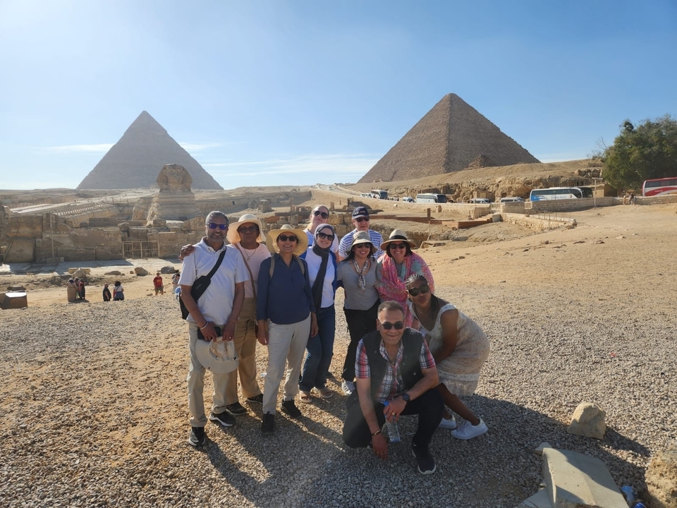 Des touristes qui prennent la pose devant les pyramides de Gizeh.