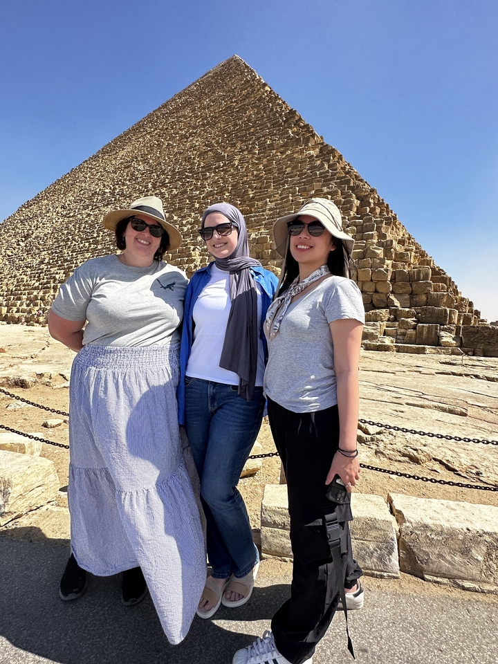 Trois personnes posant devant la Pyramide de Gizeh.