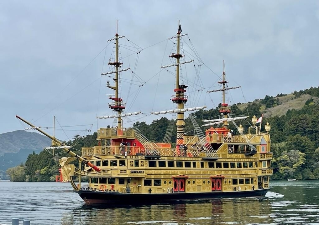 Navire pirate décoratif sur un lac avec une forêt en arrière-plan.