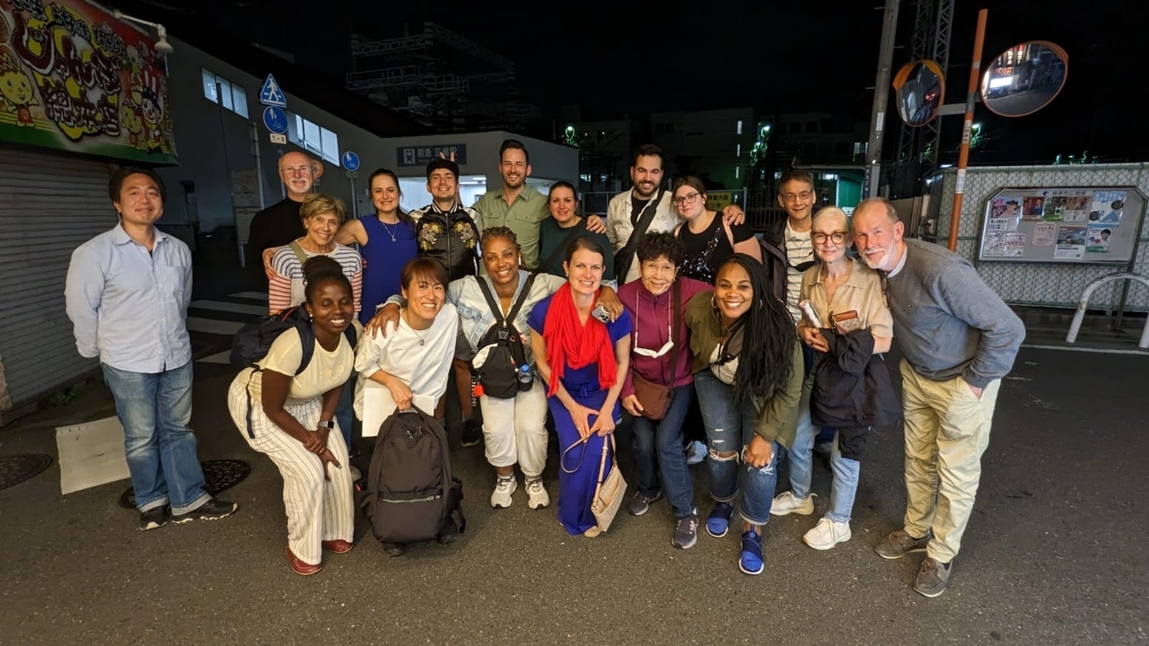 Groupe de personnes posant dans une rue la nuit.