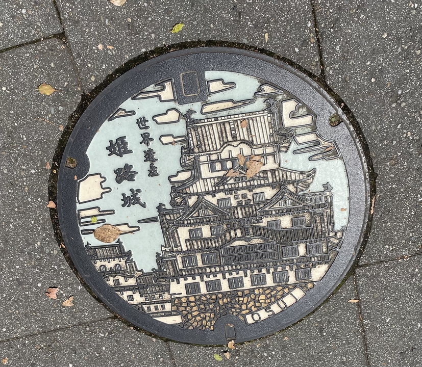 Plaque d'égout décorative représentant un château.