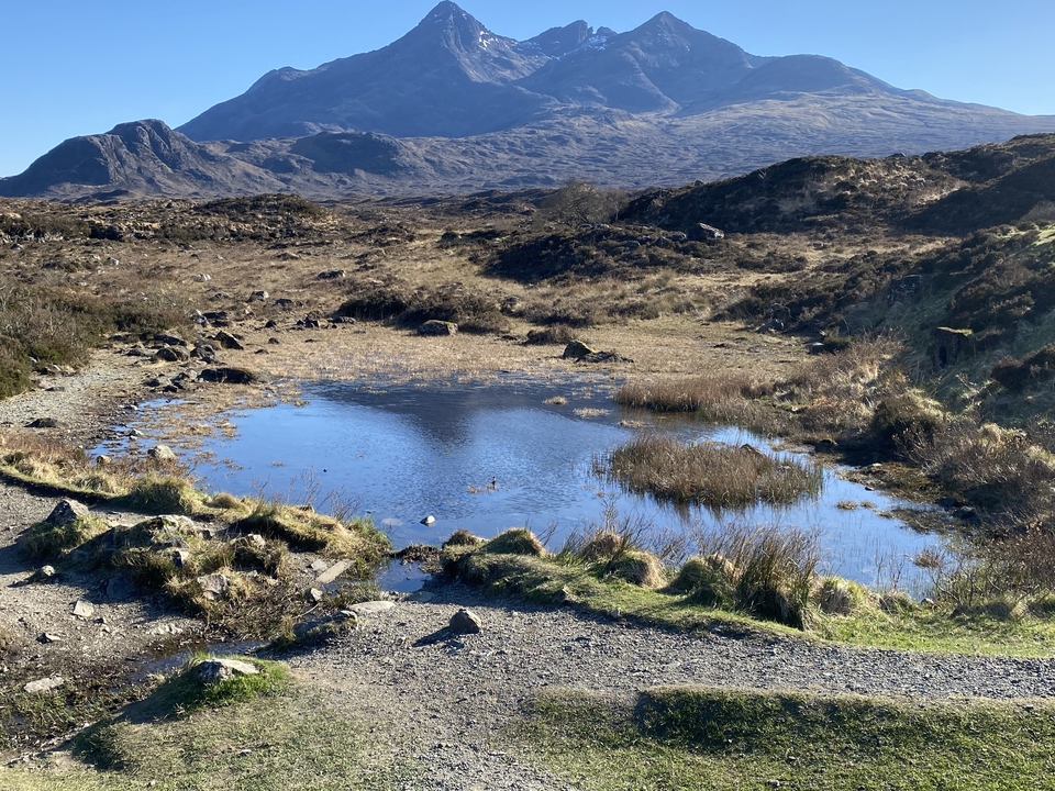 Paysage montagneux avec eau peu profonde et rochers.
