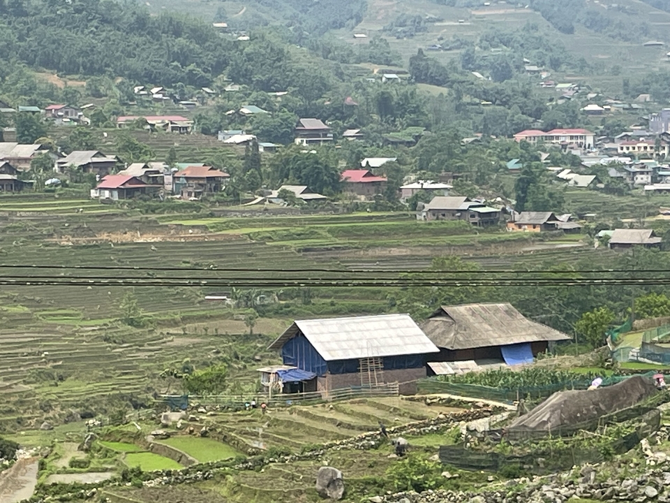 Campagne avec des champs en terrasses et des maisons dispersées.