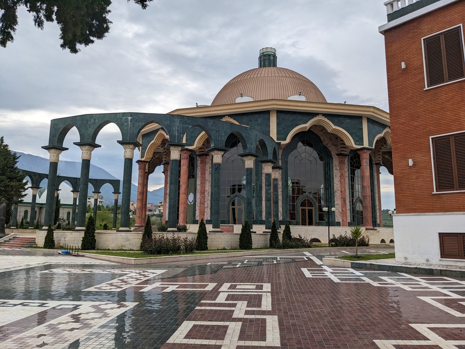 Une mosquée moderne avec un grand dôme et une façade cintrée.