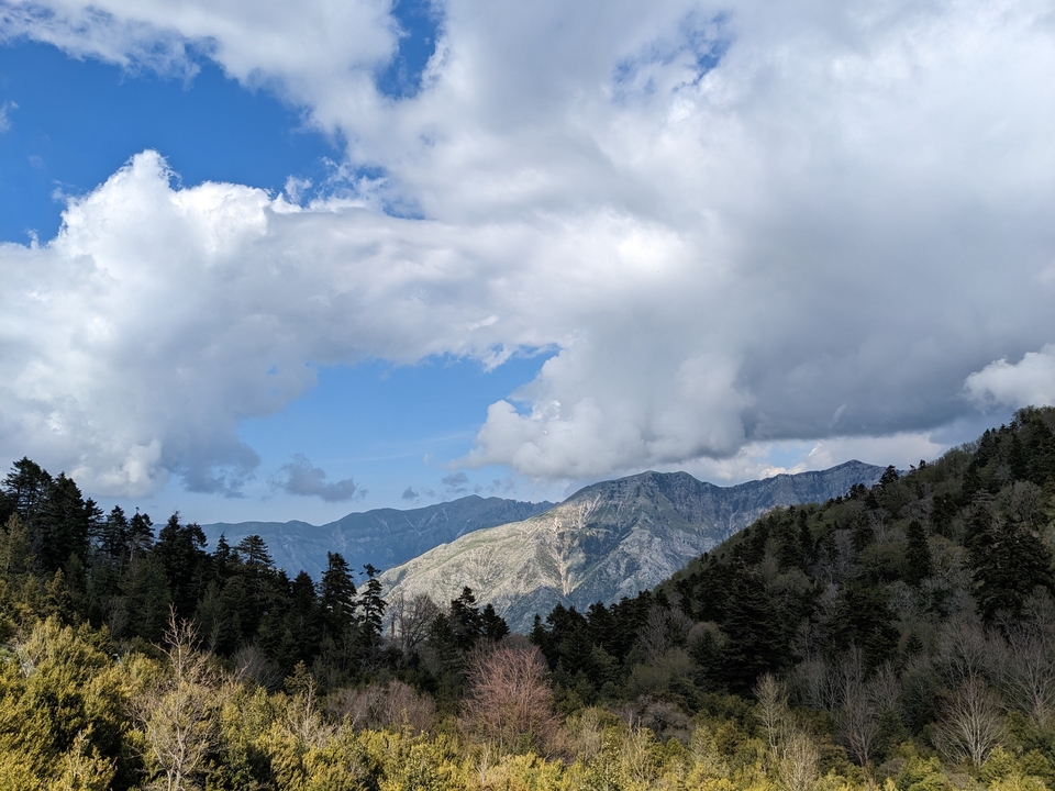 Chaîne de montagnes avec un ciel dramatique présentant des nuages et la lumière du soleil.