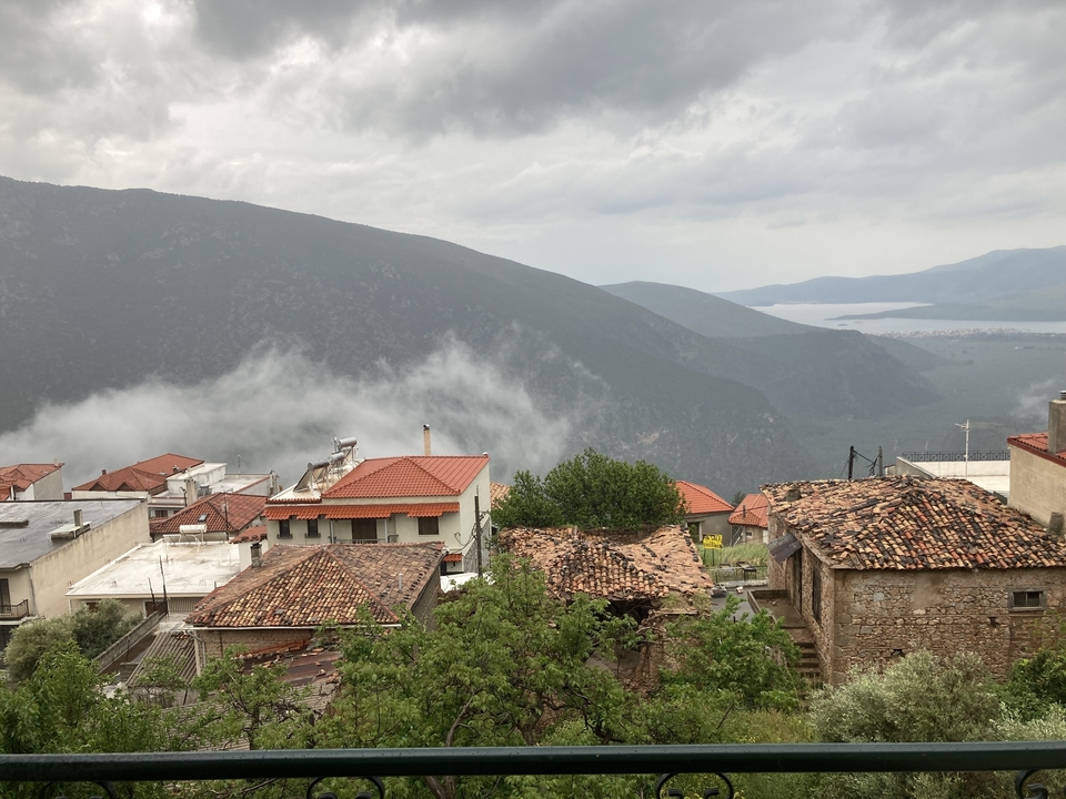 Village de montagne pittoresque avec des toits de tuiles rouges et de la brume.