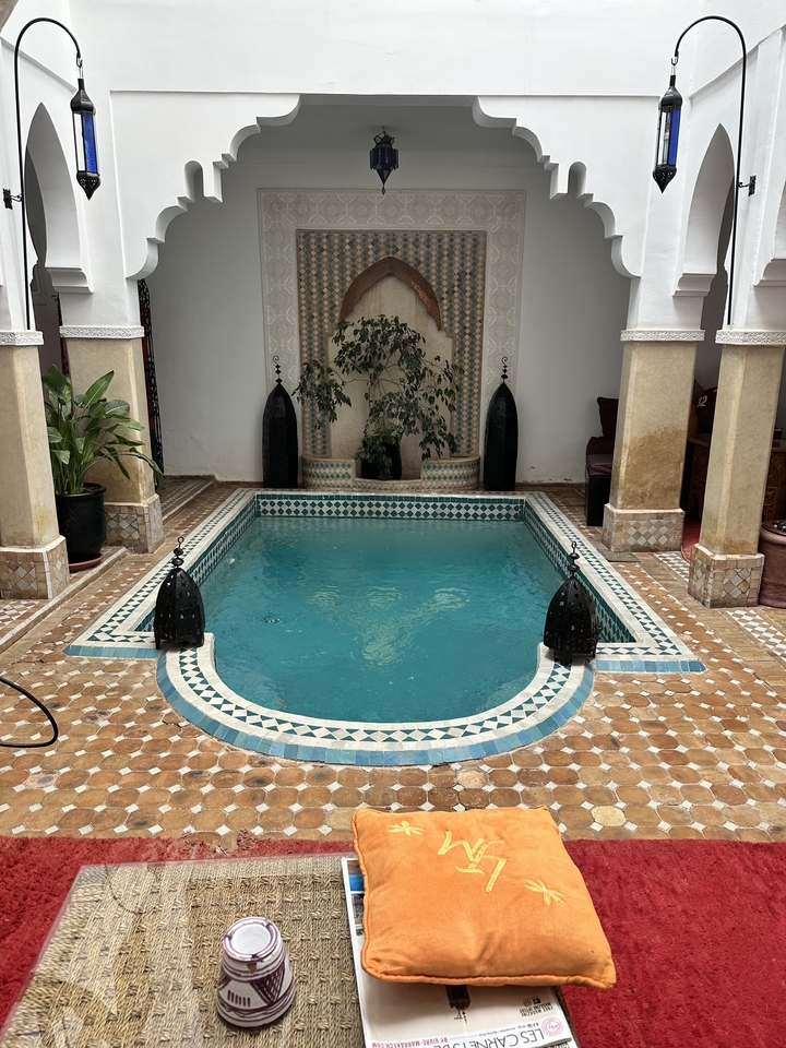 Petite piscine dans une cour carrelée.