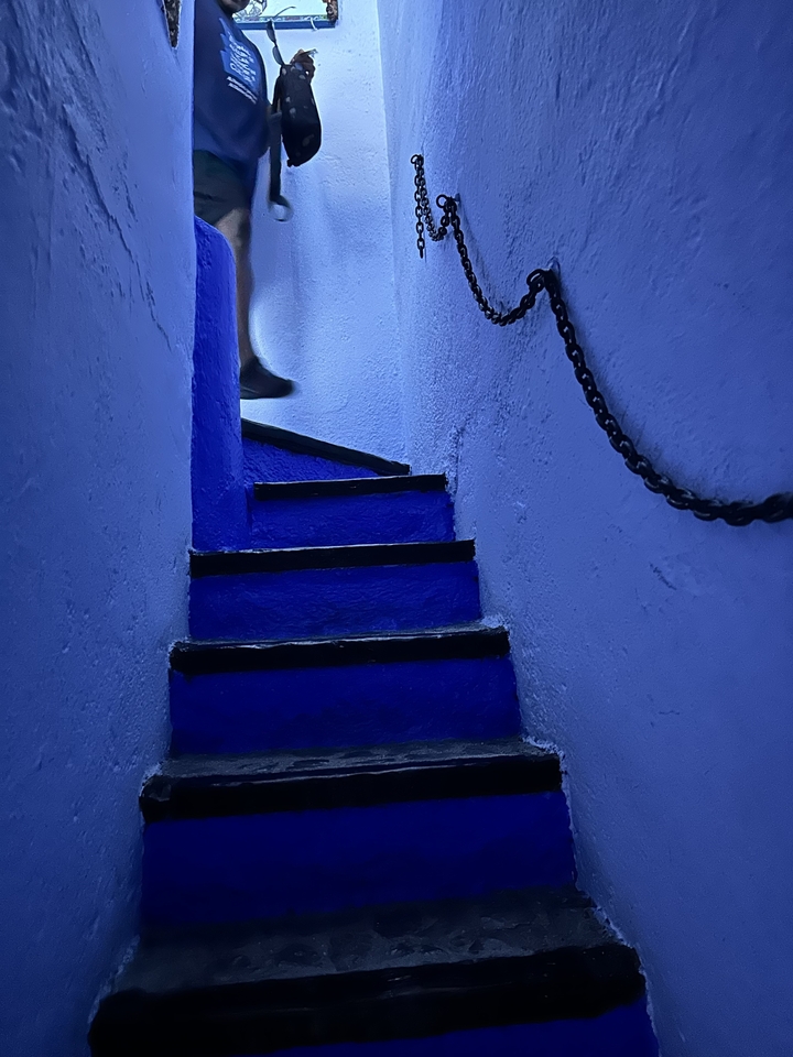 Escaliers bleus raides dans l'intérieur d'un bâtiment faiblement éclairé.