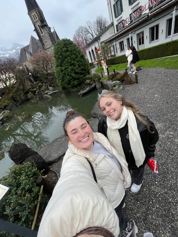 Deux personnes souriantes près d'un petit espace paysager avec un bassin.