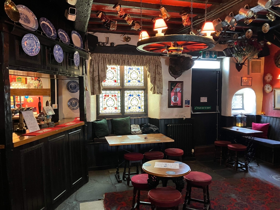 Interior acogedor de pub tradicional con vidrieras de colores.