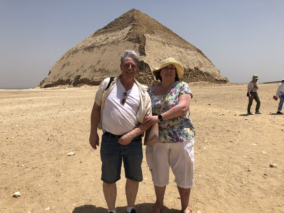 Couple posant devant une pyramide à degrés.
