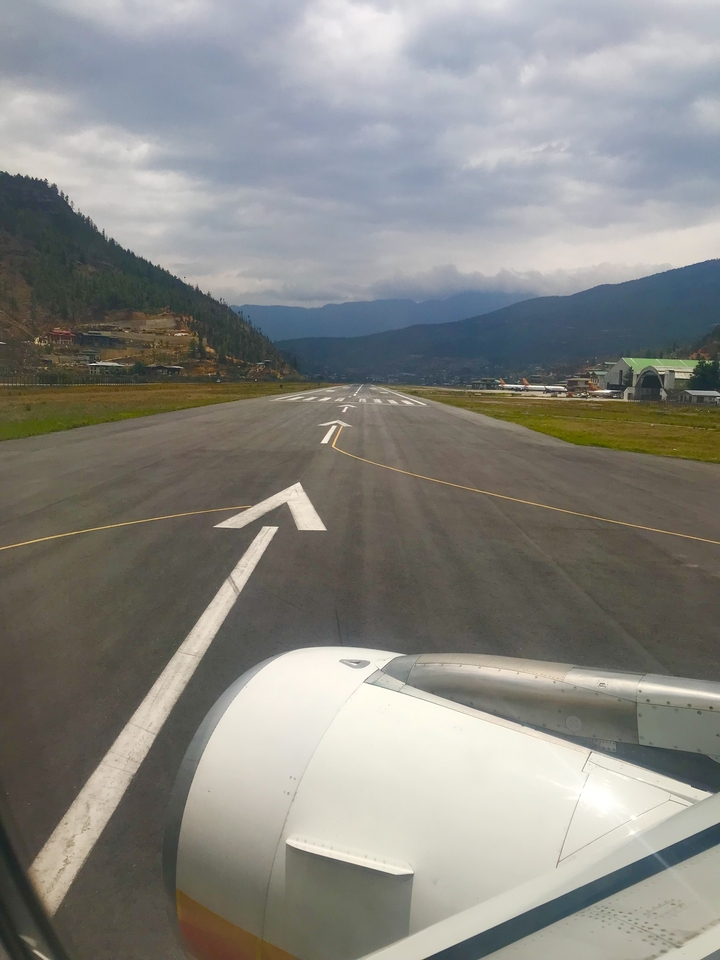 Vue aérienne d'une piste d'atterrissage dans une vallée de montagne.