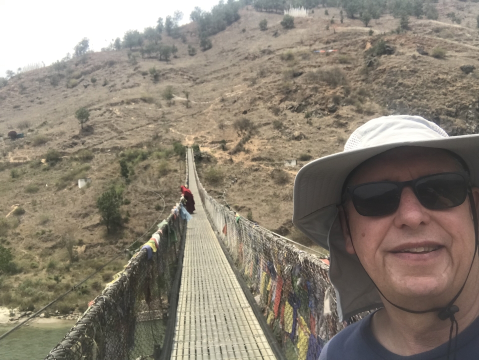 Homme prenant la pose pour un selfie sur un pont suspendu.