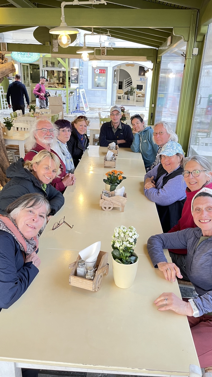 Groupe de personnes assises à une longue table de salle à manger à l'intérieur d'un restaurant.