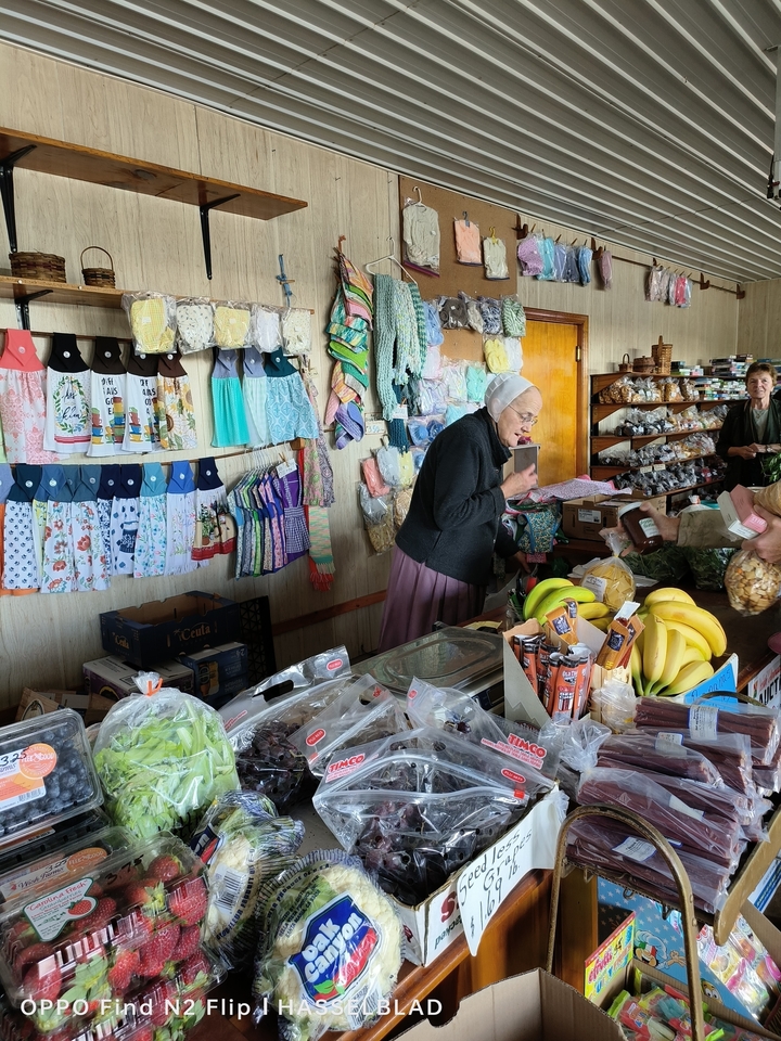 Intérieur d'une boutique avec des produits artisanaux et une femme qui sert les clients.