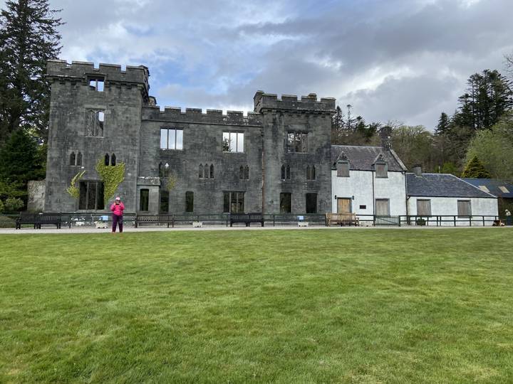Ruine de château historique avec des personnes qui observent.