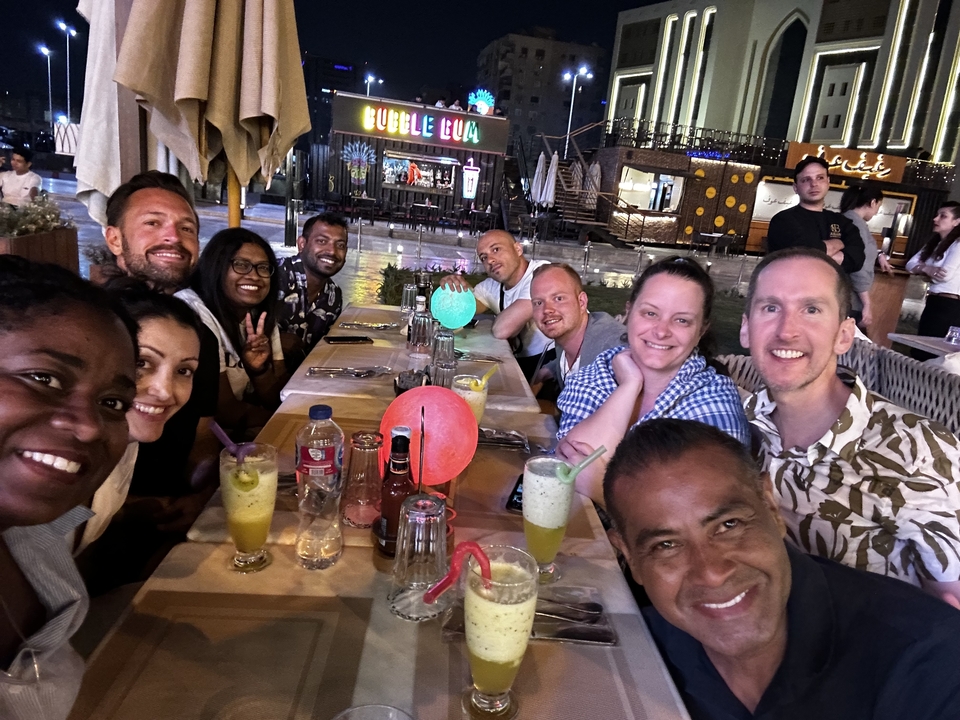 Groupe de personnes dînant en plein air la nuit.