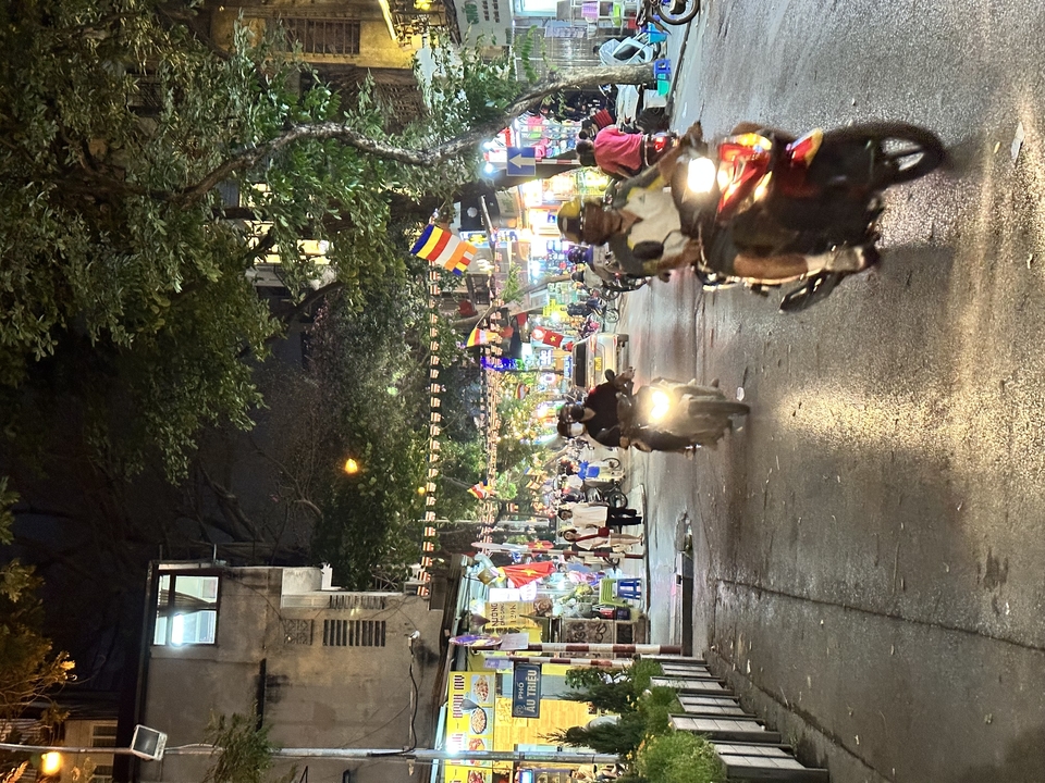 Rue animée avec des gens et des motos.
