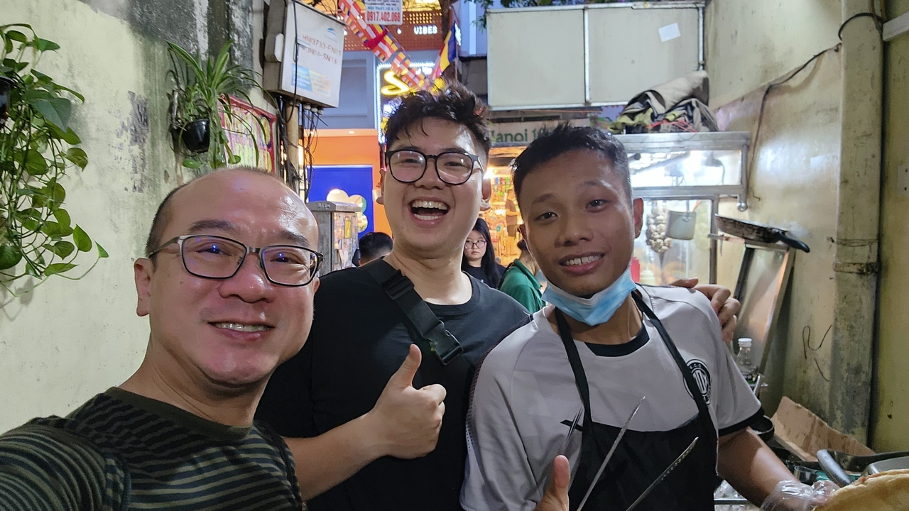 Groupe de personnes souriantes dans un petit restaurant décontracté.