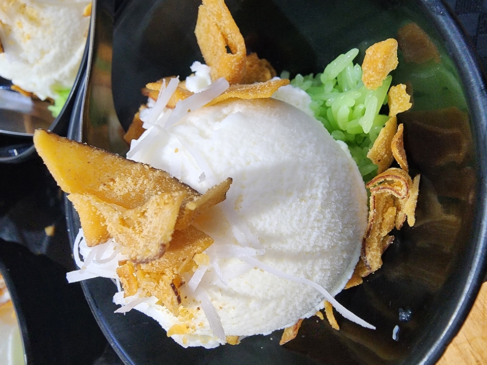 Dessert avec de la crème glacée à la noix de coco et des garnitures dans un bol.
