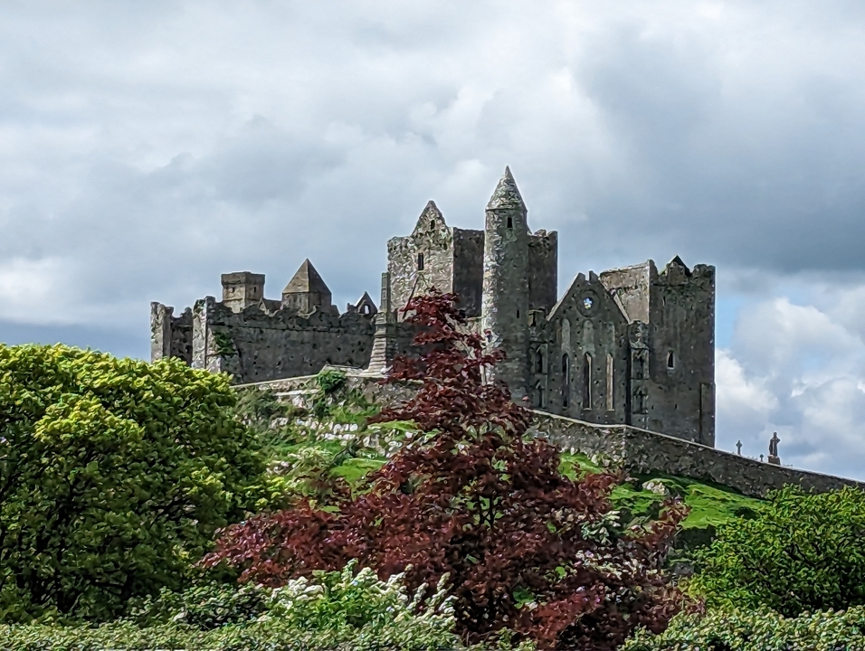 Ancien château de pierre sur une colline avec une végétation luxuriante.