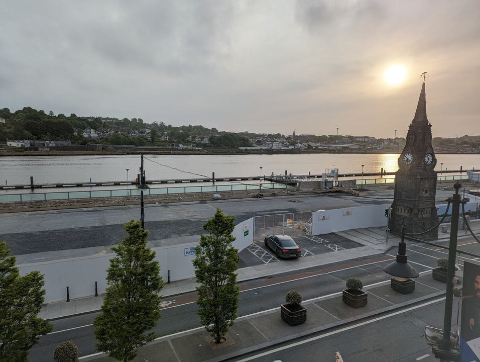 Vue sur la rivière avec un clocher au coucher du soleil.