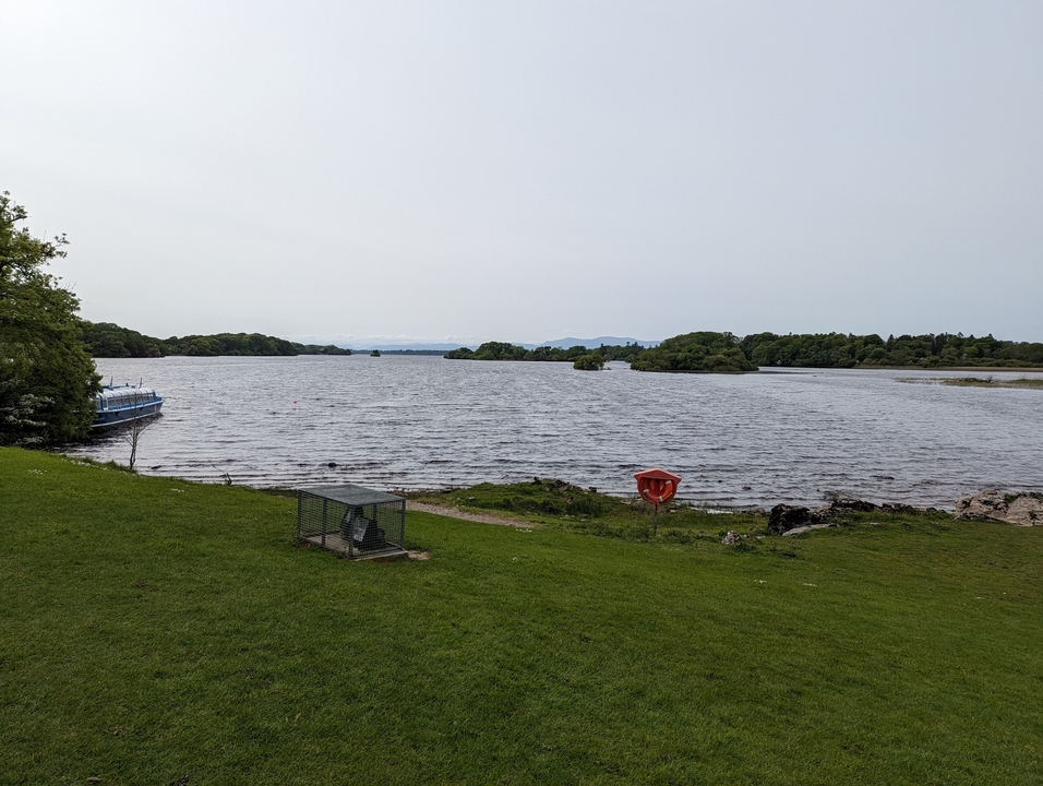 Un lac avec un bateau amarré sur le côté, entouré de verdure.