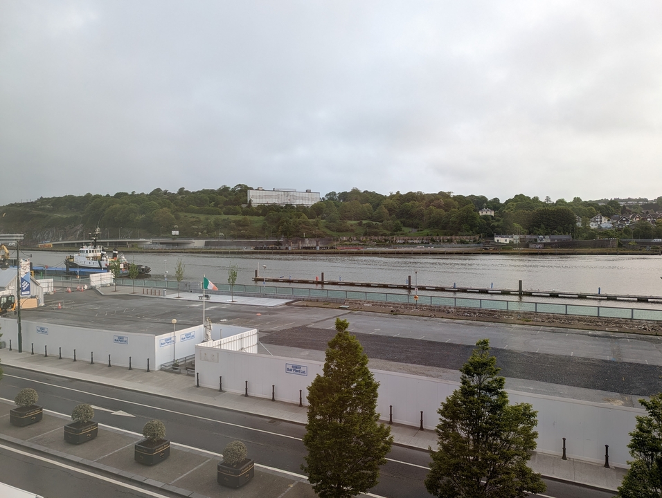 Vue sur la rivière avec un bateau et une zone d'amarrage.