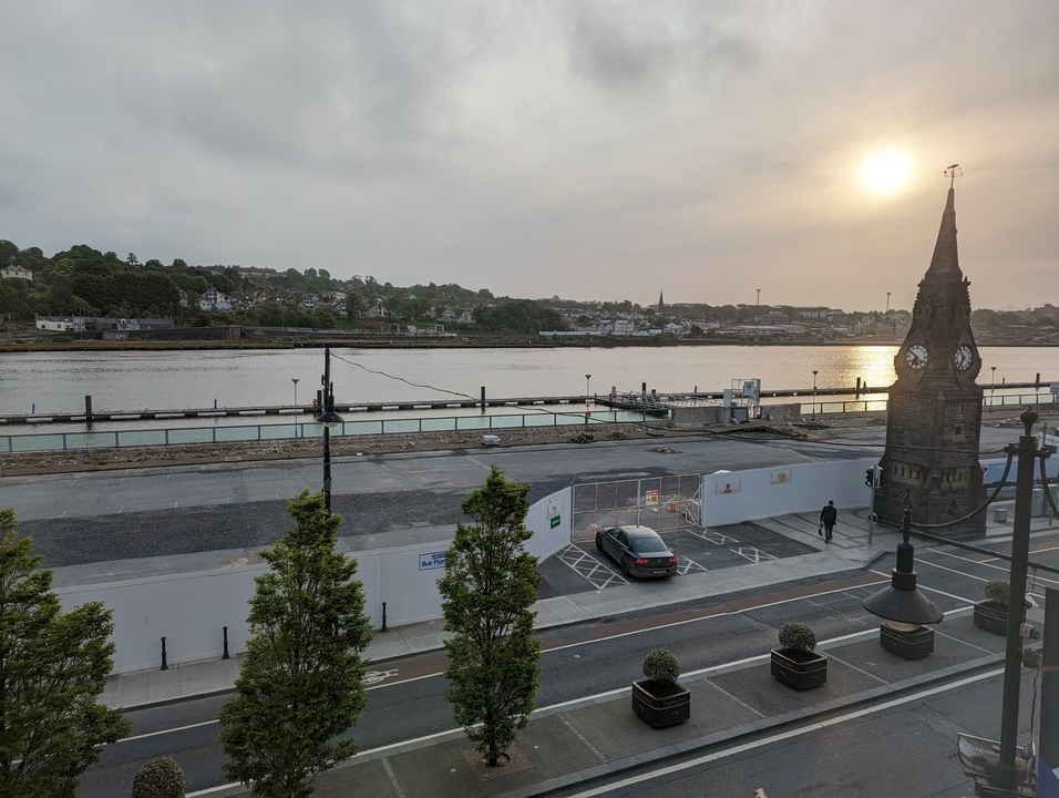 Vue sur la rivière avec un clocher au coucher du soleil.