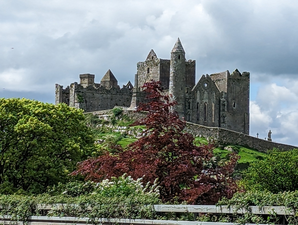 Ancien château de pierre sur une colline avec une végétation luxuriante.