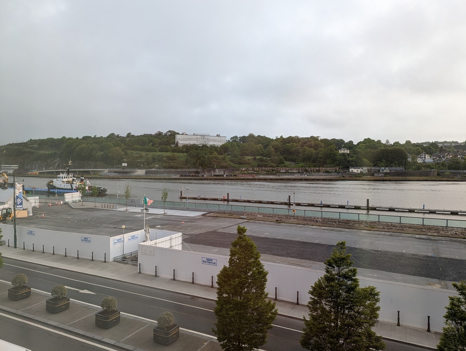 Vue sur la rivière avec un bateau et une zone d'amarrage.