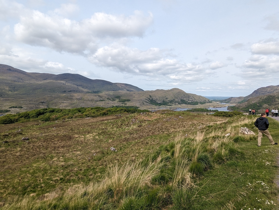 Paysage vallonné avec un groupe de personnes qui marchent.
