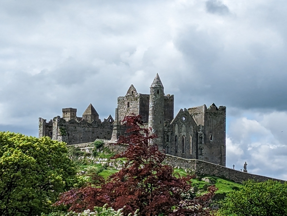 Ancien château de pierre sur une colline avec une végétation luxuriante.