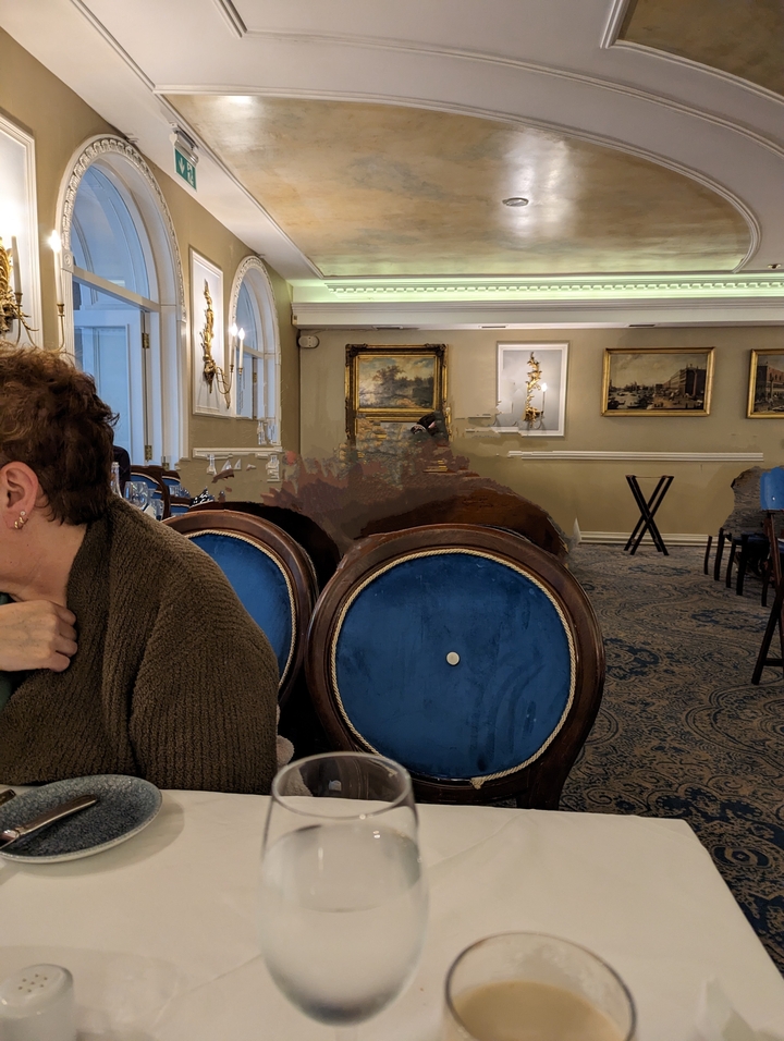 Des personnes dans un restaurant avec des œuvres d'art en arrière-plan.