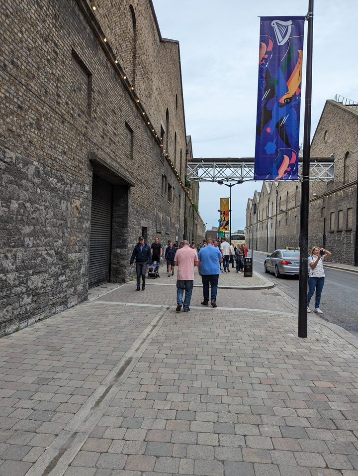 Vue de rue avec des gens qui marchent et des bannières colorées.