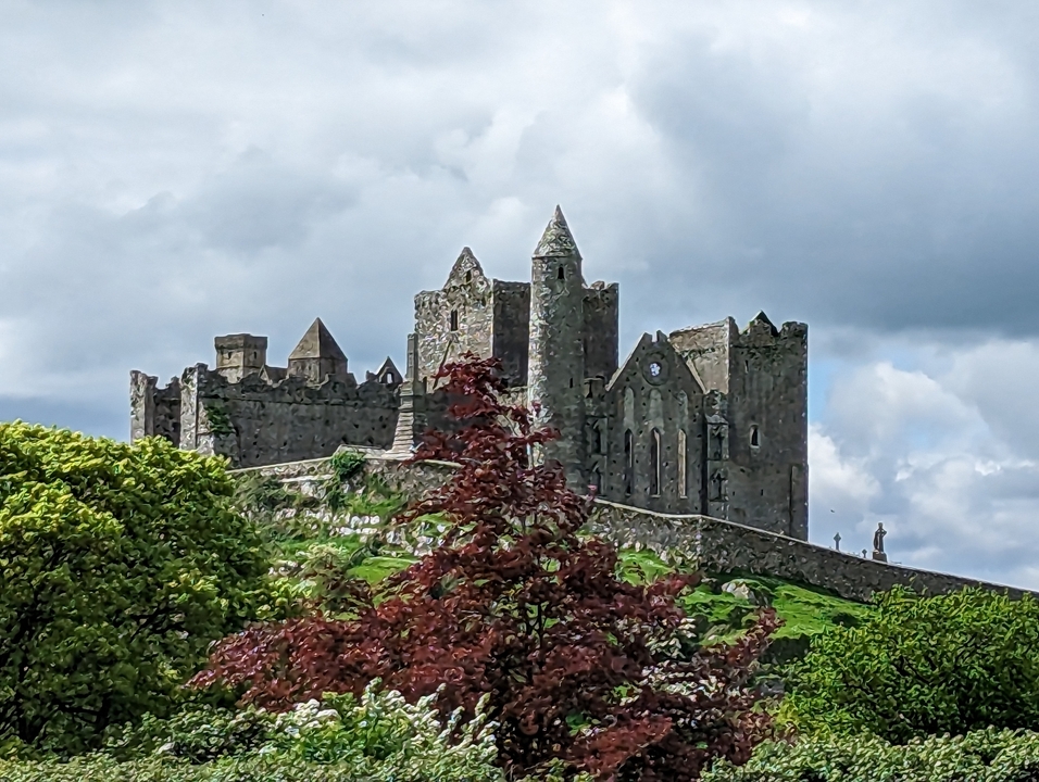Ancien château de pierre sur une colline avec une végétation luxuriante.