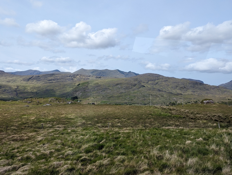 Collines ondulantes sous un ciel nuageux.