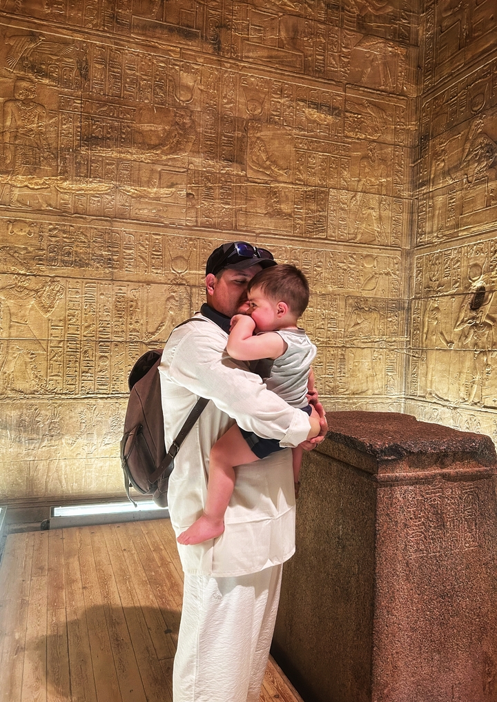 Un père réconfortant un enfant à l'intérieur d'un site de l'Égypte antique.
