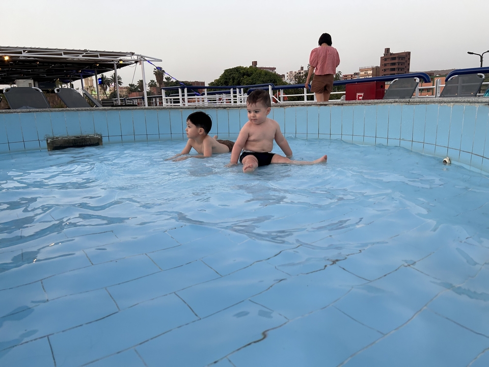 Deux enfants jouant dans une petite piscine.