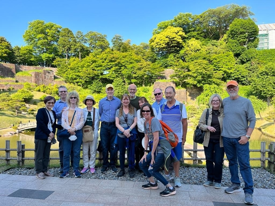 Groupe de personnes posant dans un parc verdoyant.